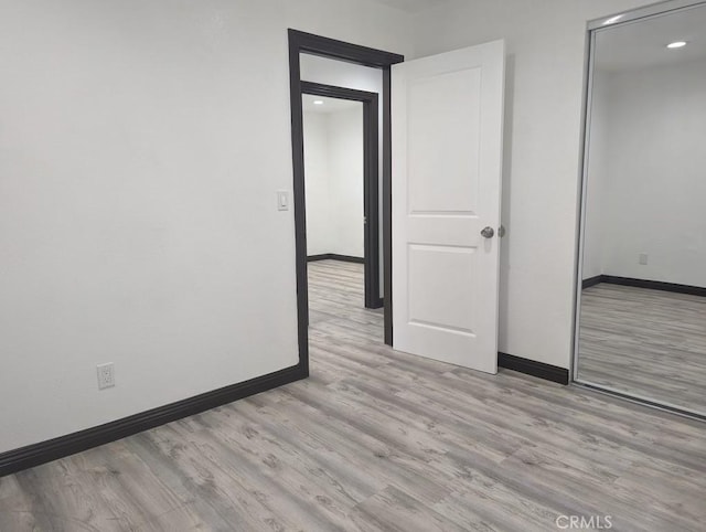 unfurnished bedroom with a closet and light hardwood / wood-style floors