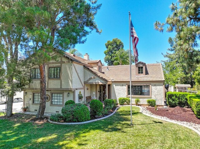 english style home featuring a front lawn