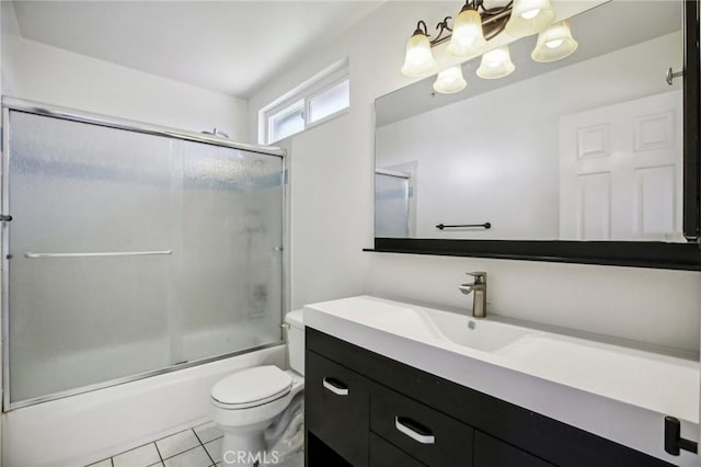 full bathroom with tile patterned flooring, vanity, bath / shower combo with glass door, and toilet