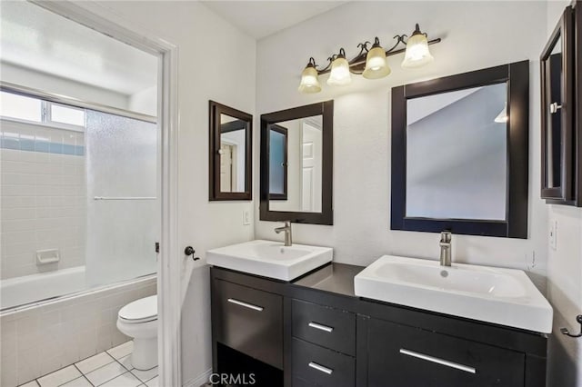 full bathroom with tile patterned flooring, vanity, bath / shower combo with glass door, and toilet