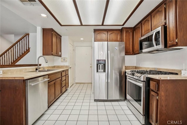 kitchen featuring sink, light tile patterned floors, and stainless steel appliances