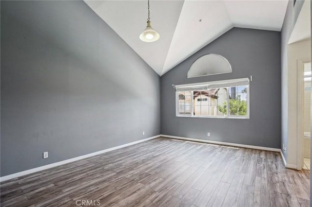 empty room featuring hardwood / wood-style flooring and high vaulted ceiling