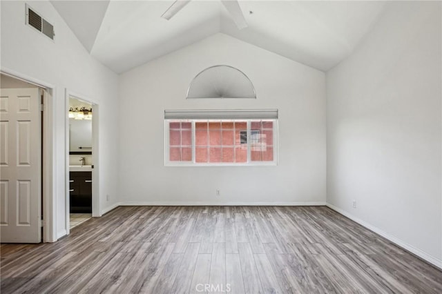 unfurnished bedroom with light wood-type flooring, high vaulted ceiling, ceiling fan, and connected bathroom