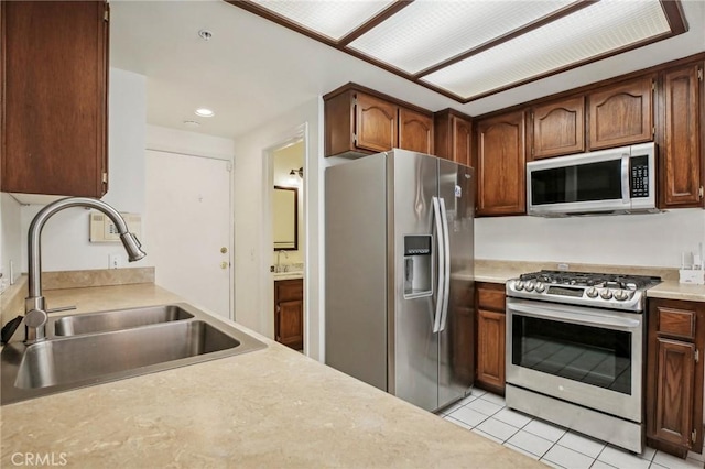 kitchen featuring light tile patterned flooring, sink, and stainless steel appliances