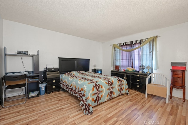 bedroom with a textured ceiling and light hardwood / wood-style flooring