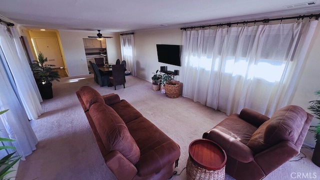 living room featuring a ceiling fan, light colored carpet, and visible vents