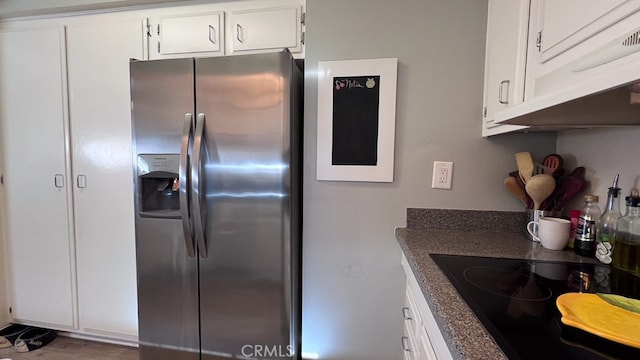 kitchen featuring black electric stovetop, white cabinets, and stainless steel fridge with ice dispenser