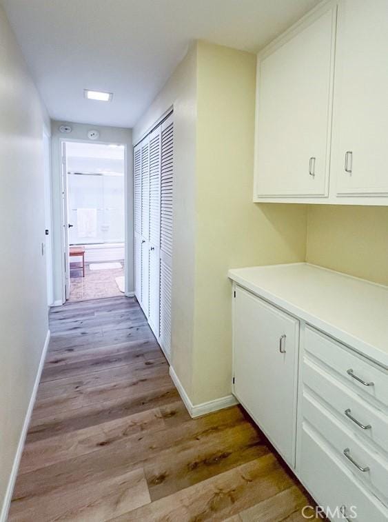 hallway with baseboards and light wood-style flooring