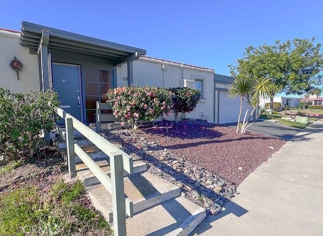 view of property exterior with stucco siding, driveway, and a garage