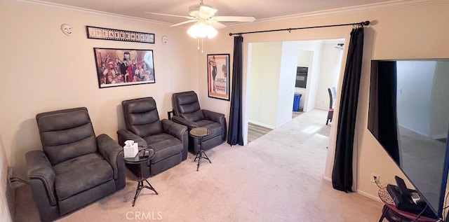 sitting room with ceiling fan, carpet, baseboards, and ornamental molding