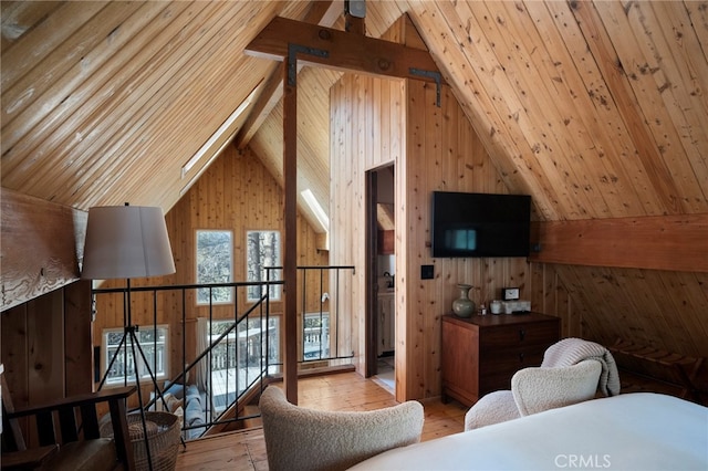 interior space featuring light hardwood / wood-style floors, lofted ceiling, and wooden walls