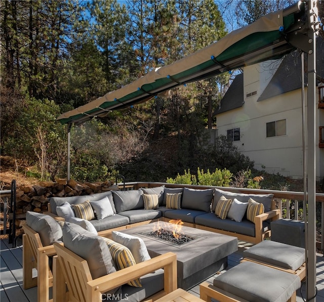 wooden terrace featuring an outdoor living space with a fire pit