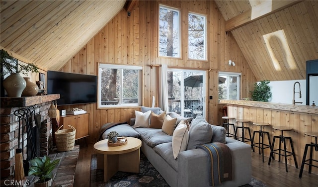 living room featuring high vaulted ceiling, dark hardwood / wood-style flooring, wooden walls, and a fireplace