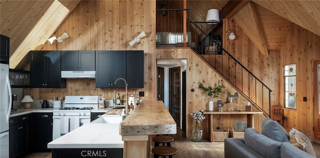 kitchen with gas range gas stove, wooden ceiling, high vaulted ceiling, and wood-type flooring