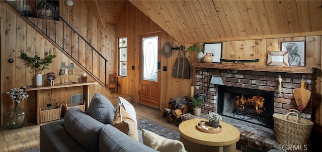 living room featuring hardwood / wood-style floors, vaulted ceiling, a brick fireplace, and wooden walls