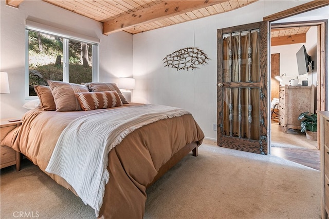 carpeted bedroom featuring beam ceiling and wooden ceiling