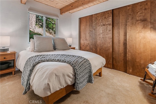 carpeted bedroom featuring beam ceiling and wood ceiling