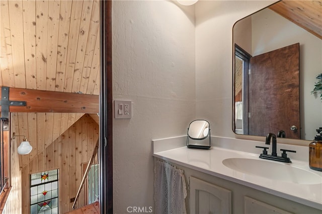 bathroom with vanity and wood walls