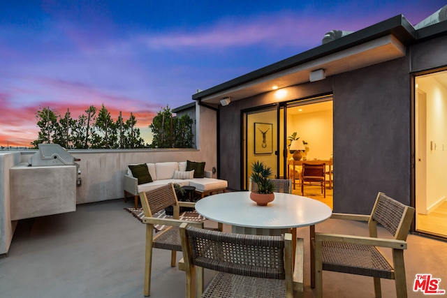 patio terrace at dusk featuring an outdoor living space