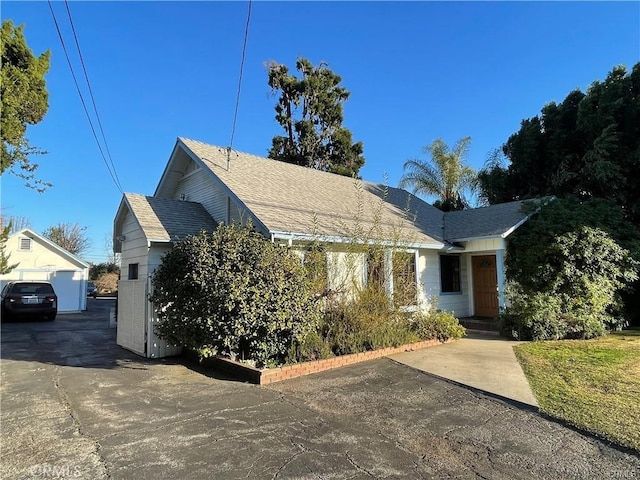 view of front of home with a garage and an outbuilding