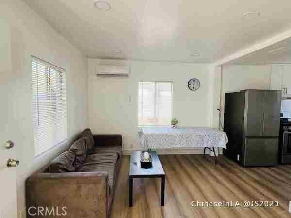 living room with wood-type flooring and a wall mounted AC