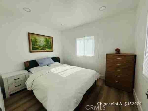 bedroom with dark wood-type flooring