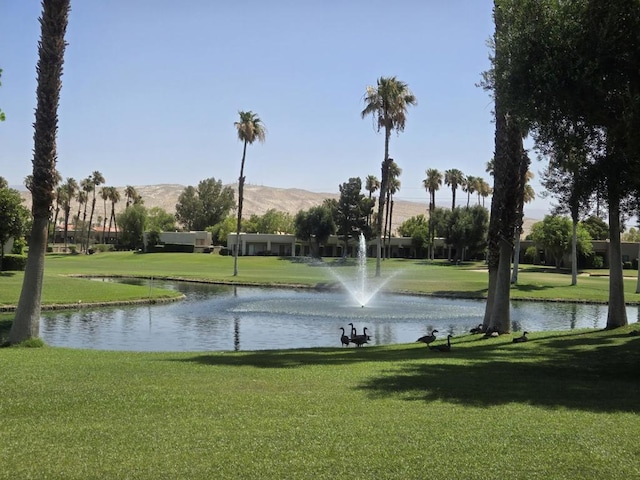 surrounding community with a lawn and a water and mountain view