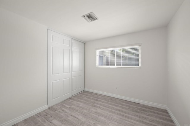 unfurnished bedroom with a closet and light hardwood / wood-style flooring