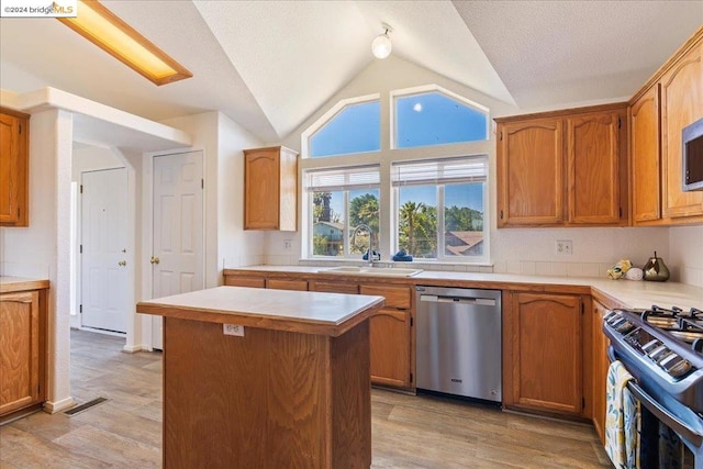 kitchen featuring stove, lofted ceiling, dishwasher, a center island, and light wood-type flooring