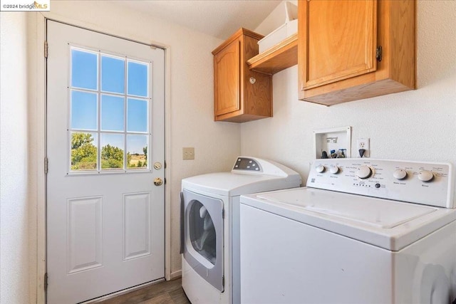 clothes washing area featuring cabinets, dark wood-type flooring, and washer and dryer