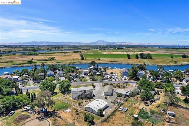 drone / aerial view with a water and mountain view and a rural view