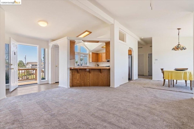 unfurnished living room with lofted ceiling with beams and light colored carpet