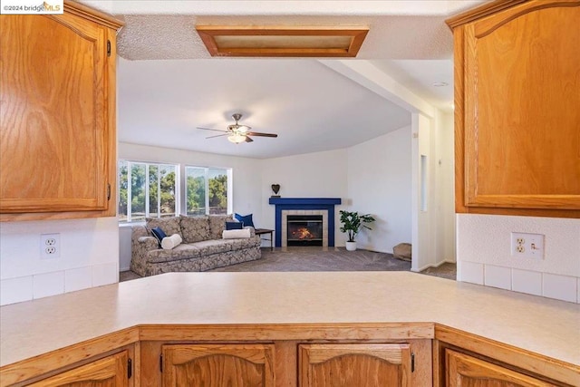 kitchen with ceiling fan, a textured ceiling, and a fireplace