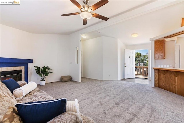 carpeted living room featuring ceiling fan and a tile fireplace