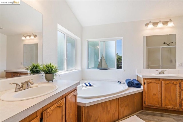 bathroom featuring shower with separate bathtub, lofted ceiling, vanity, and hardwood / wood-style flooring