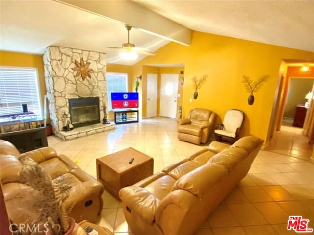 tiled living room with vaulted ceiling with beams, ceiling fan, and a fireplace