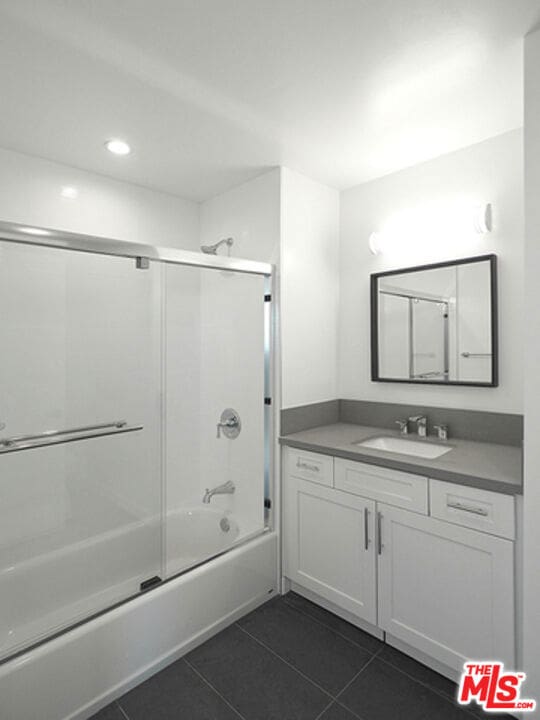 bathroom featuring shower / bath combination with glass door, vanity, and tile patterned flooring