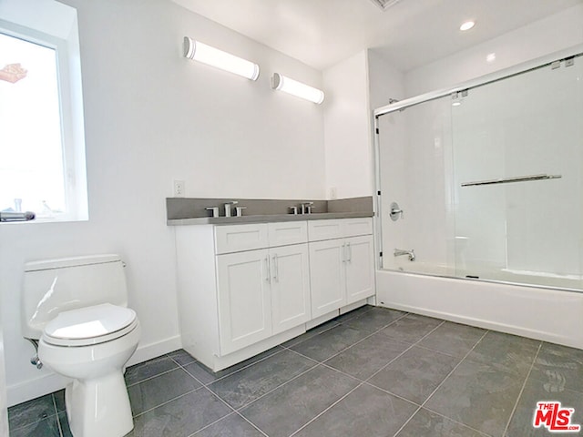 full bathroom with tile patterned floors, vanity, enclosed tub / shower combo, and toilet