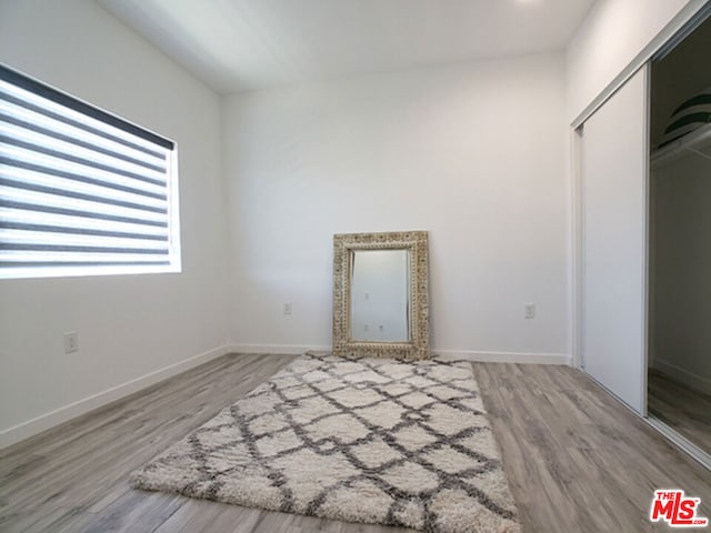 unfurnished bedroom with a closet and hardwood / wood-style flooring