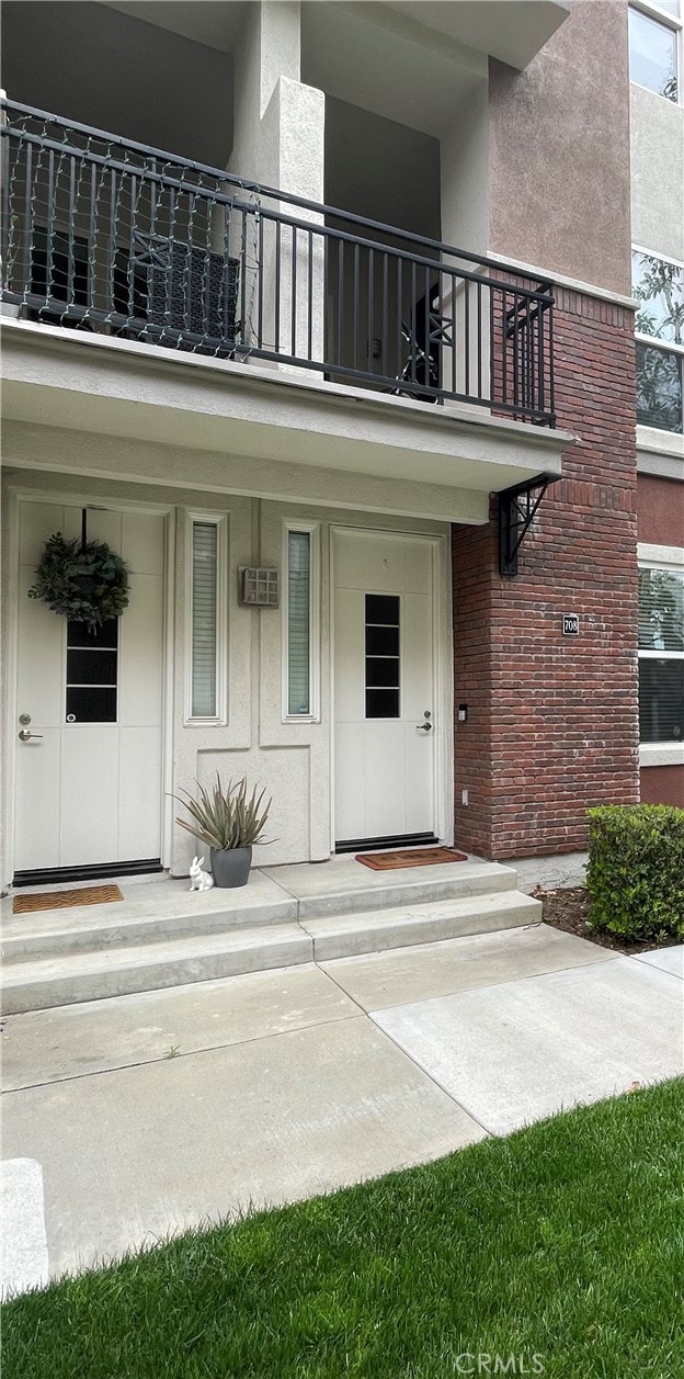 view of exterior entry featuring a balcony