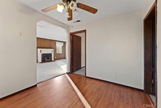 spare room with wood-type flooring, ceiling fan, and a textured ceiling