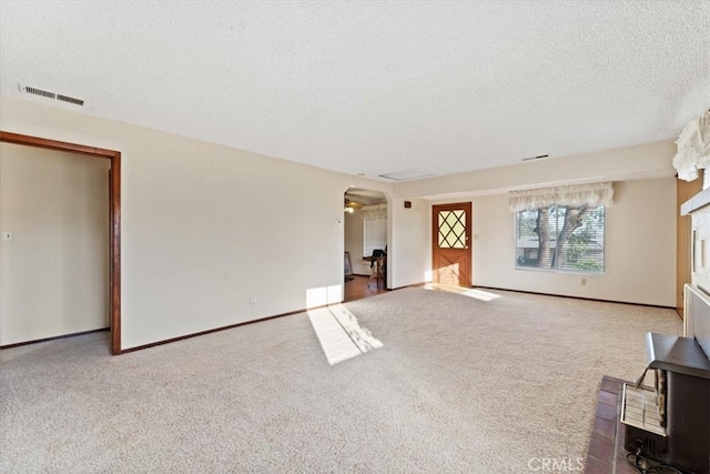 unfurnished living room featuring carpet floors and a textured ceiling