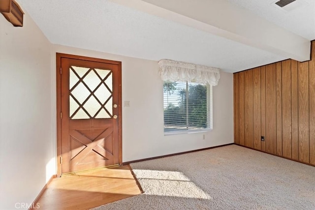 interior space featuring wood walls, baseboards, and visible vents