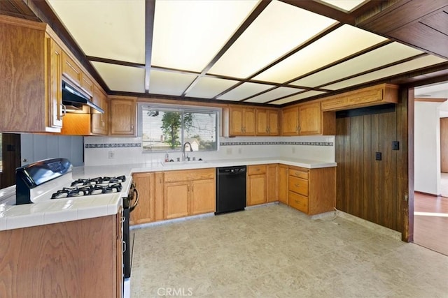 kitchen with range with gas stovetop, black dishwasher, under cabinet range hood, light floors, and a sink