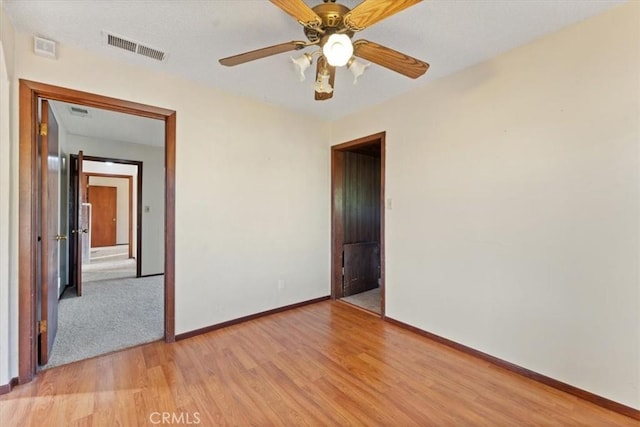 spare room with visible vents, light wood-style flooring, and baseboards