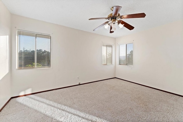 spare room with ceiling fan, plenty of natural light, and carpet flooring