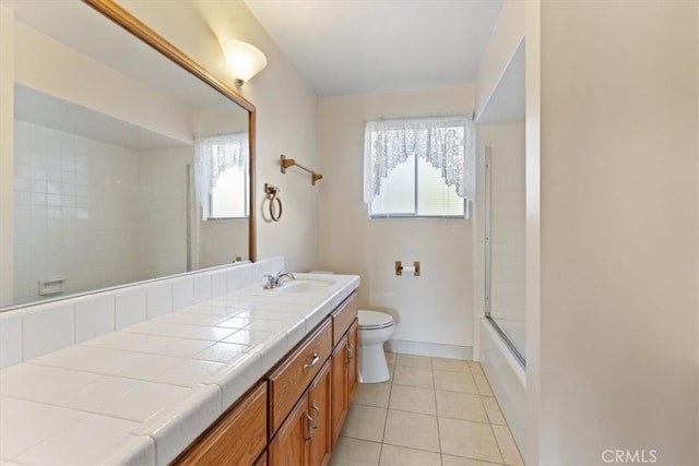 full bathroom featuring combined bath / shower with glass door, vanity, toilet, and tile patterned floors