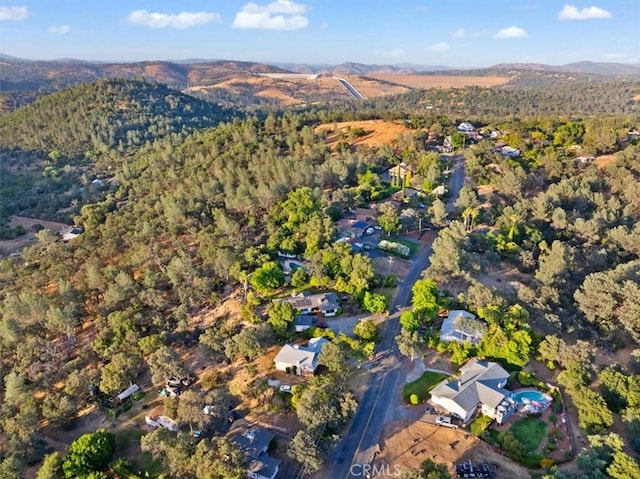 birds eye view of property featuring a wooded view and a mountain view
