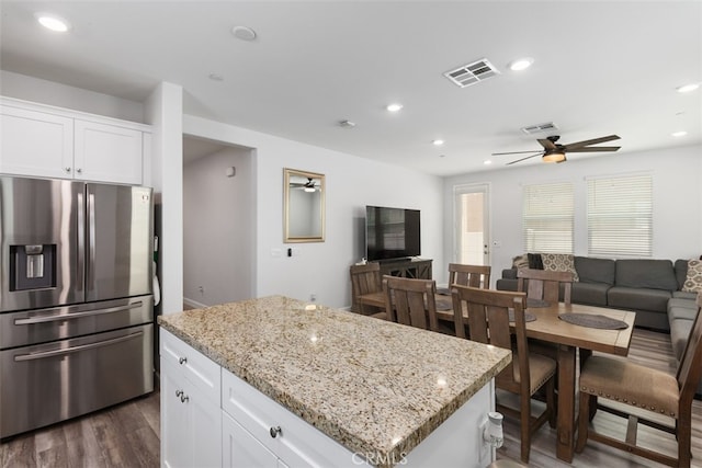 kitchen with stainless steel fridge with ice dispenser, dark hardwood / wood-style flooring, white cabinetry, and a kitchen island