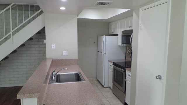 kitchen featuring light tile patterned floors, white cabinetry, sink, and appliances with stainless steel finishes